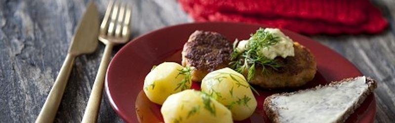 Frikadeller og kartofler på en rød tallerken