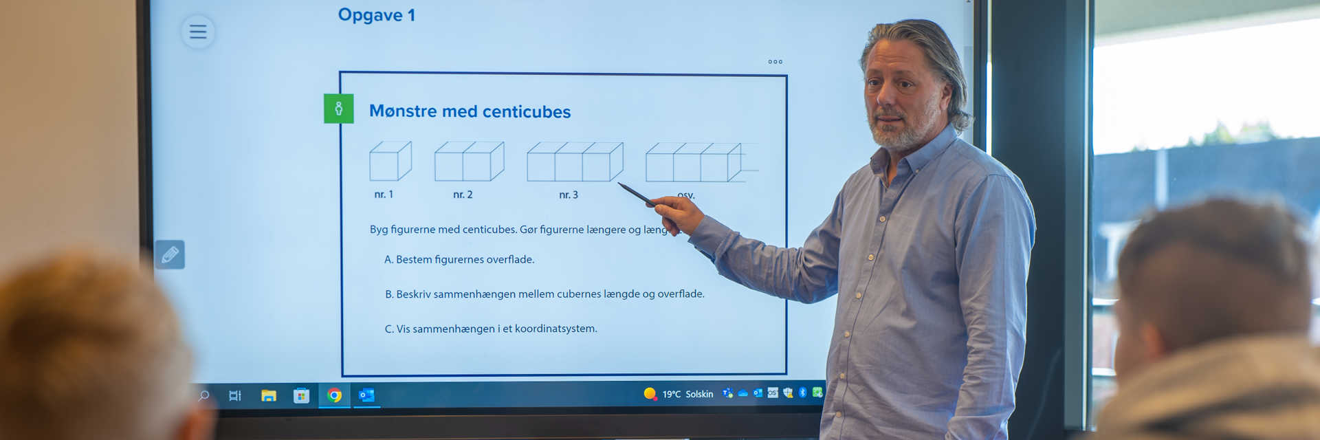 Mand står og underviser foran et stort whiteboard