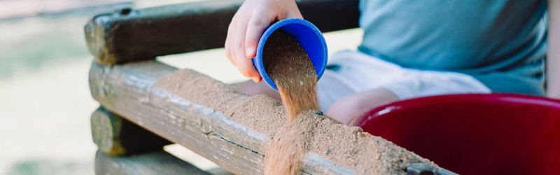Barn leger med sand