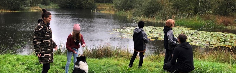 Familie fisker ved en sø