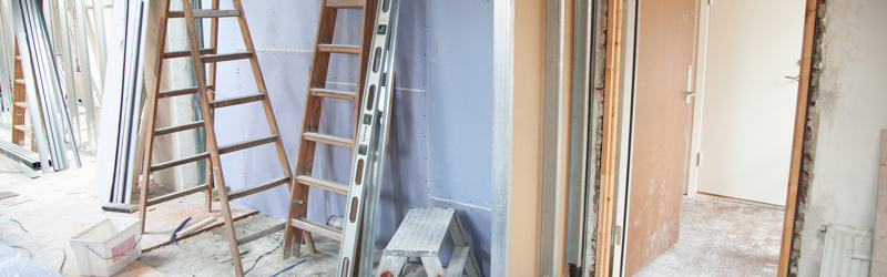 Billedet viser et hus under ombygning - rå vægge , stiger, maling