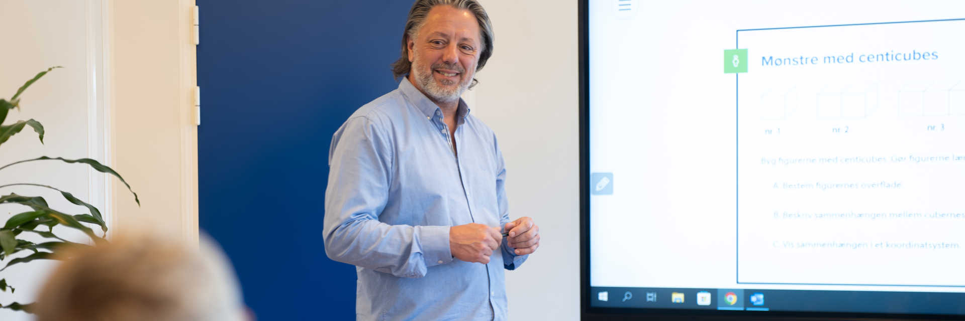Mand i gang med at undervise foran et stort whiteboard