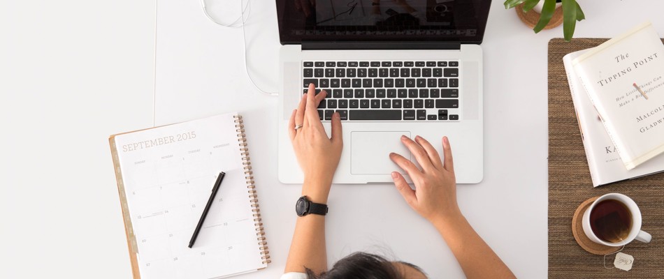 Kvinde sidder foran sin bærbar computer og arbejder