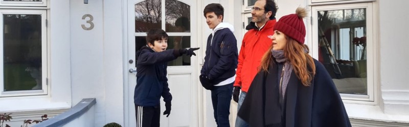 Family standing next to a house
