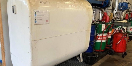 Hvid olietank - står i en staldbygning