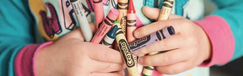 Close-up of child holding crayons