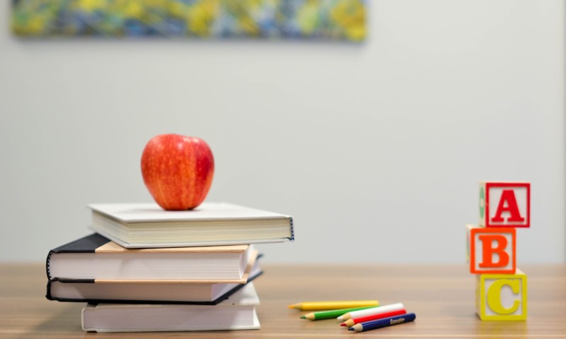 Æble staplet på nogle skolebøger Æble staplet på nogle skolebøger